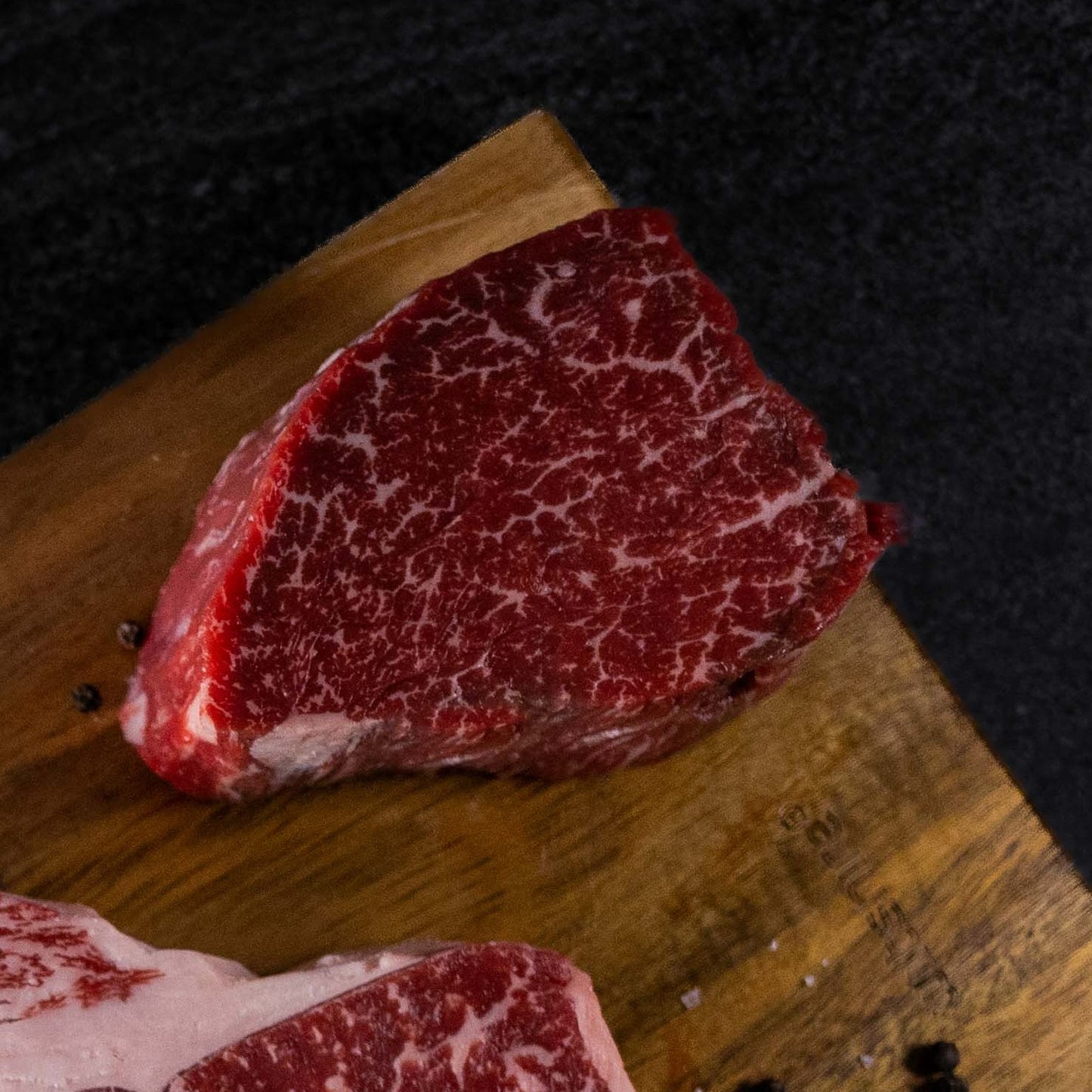 Raw beef steak with marbling on a wooden cutting board