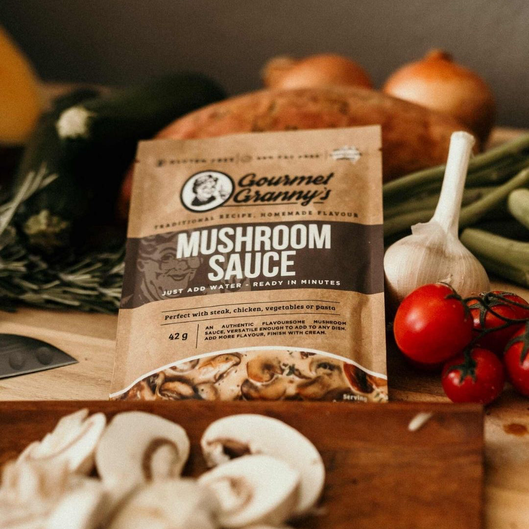Gourmet Granny's Mushroom Sauce package on a wooden surface with mushrooms and vegetables.