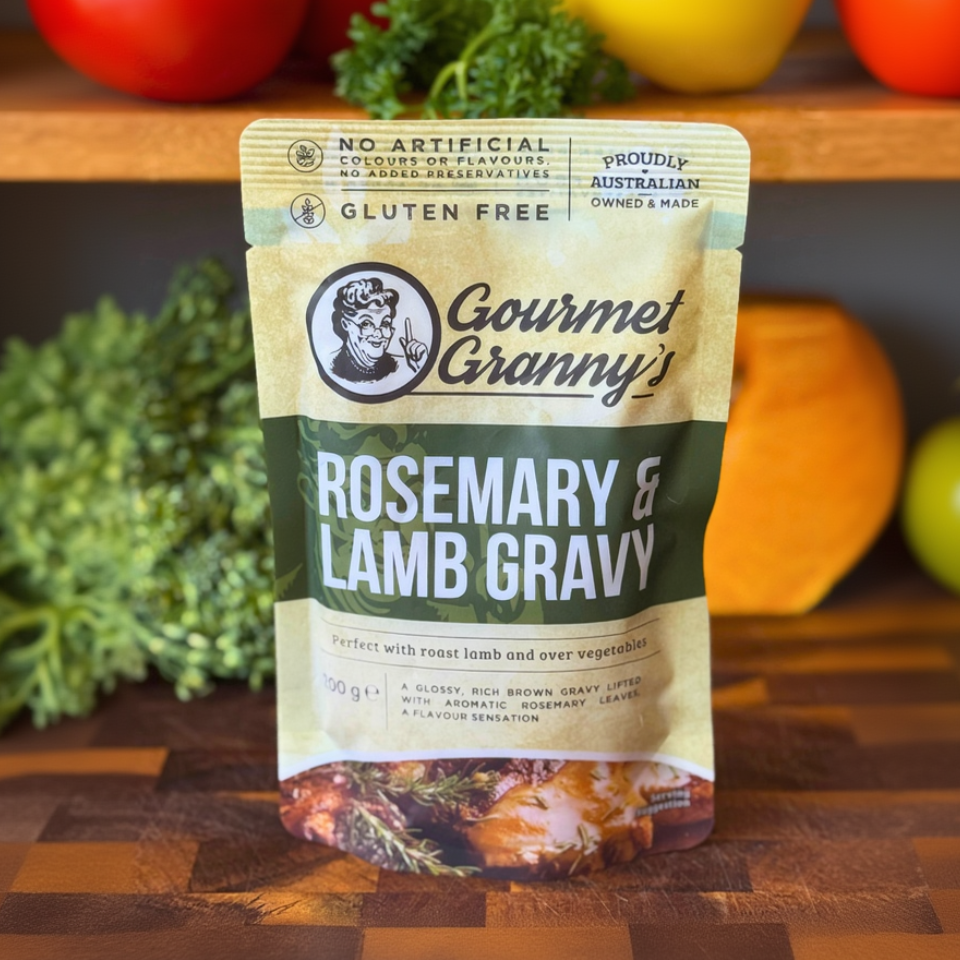 Gourmet Granny's Rosemary & Lamb Gravy packet on a wooden surface with vegetables in the background